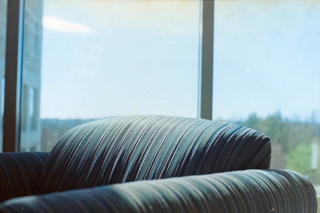 A black couch sitting in front of a window