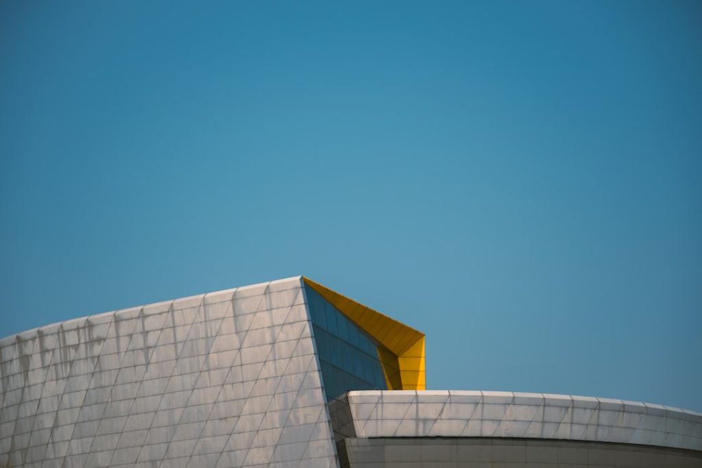 a building with a yellow roof and a blue sky in the background