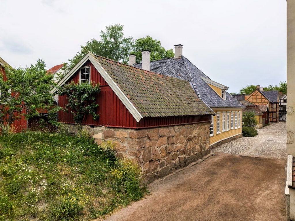 A red house sitting on top of a dirt road
