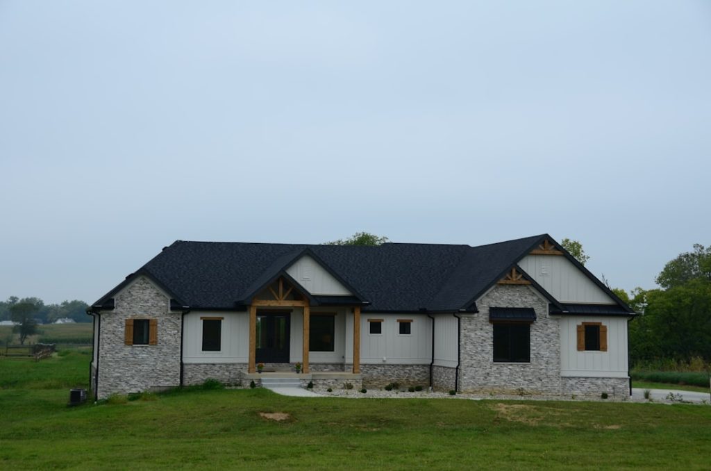 a stone house with a black roof and windows