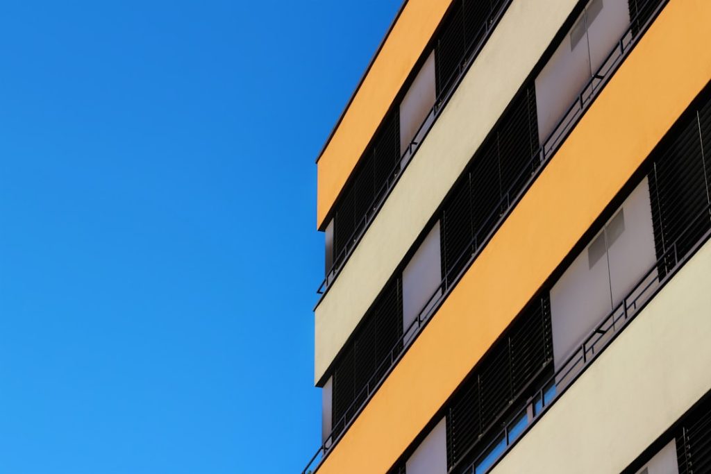 an orange and white building with a blue sky in the background